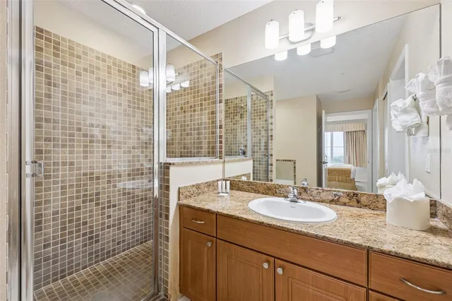 a bathroom with a granite countertop sink a mirror and shower