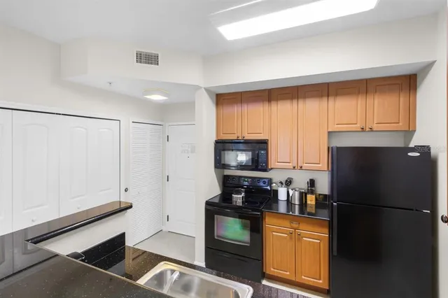a kitchen with granite countertop a refrigerator stove and microwave