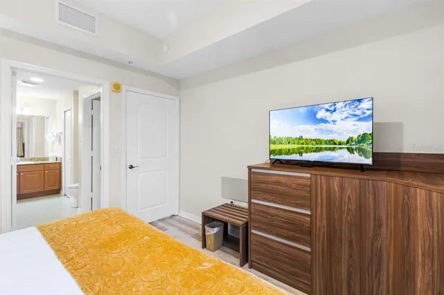 a bedroom with a bed and a flat screen tv