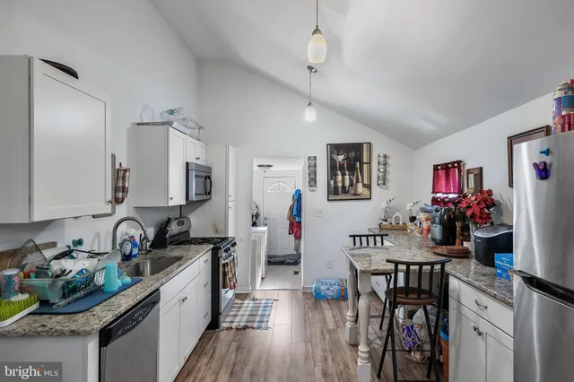 a kitchen that has a lot of cabinets in it and wooden floors