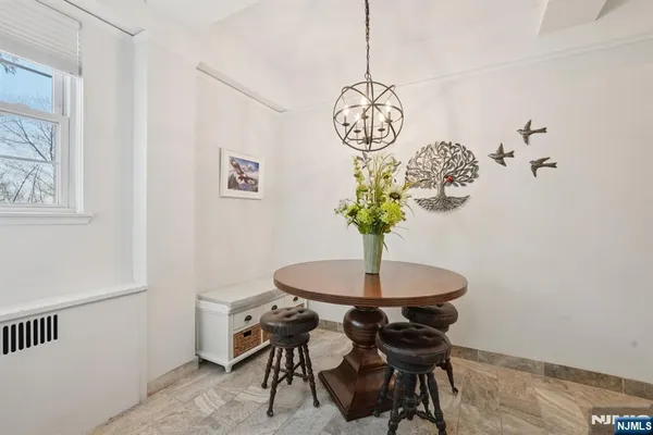 a view of a dining room with furniture a chandelier and wooden floor