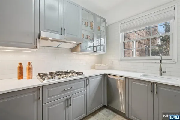 a kitchen with stainless steel appliances granite countertop a sink stove and cabinets