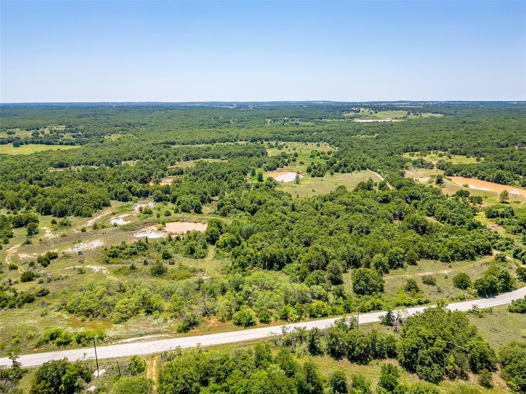 613 County Road 3848 Poolville, TX 76487 - Photo 35 of 40 an aerial view of residential houses with outdoor space and trees