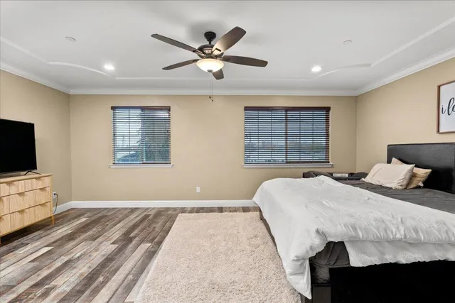 a spacious bedroom with a large bed and ceiling fan