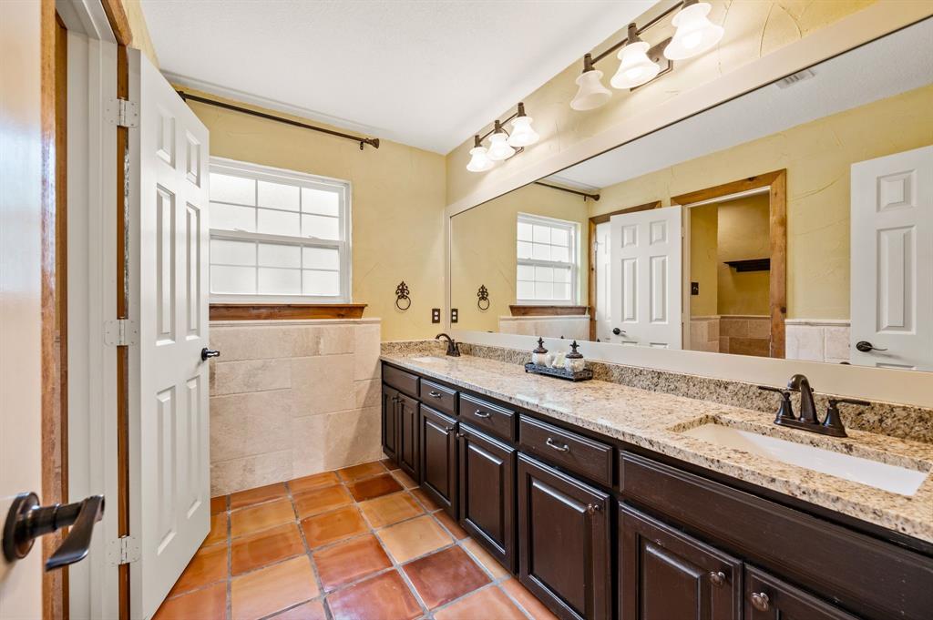 2141 Old Denton Road Decatur, TX 76234 - Photo 25 of 40 Upstairs bathroom featuring double vanities and a walk-in shower.