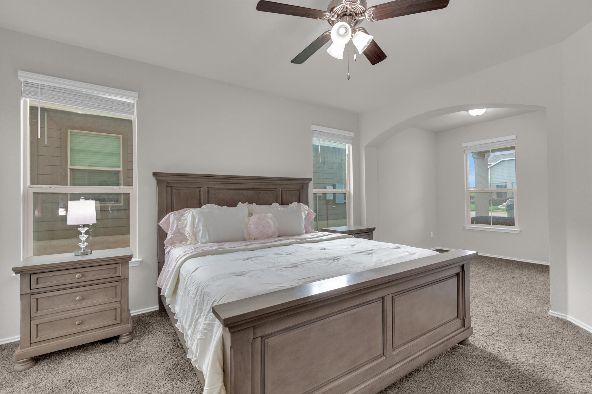 104 Uncle Billy Way Jarrell, TX 76537 - Photo 10 of 38 A tranquil primary bedroom with plush carpeting and natural light filtering through multiple windows.