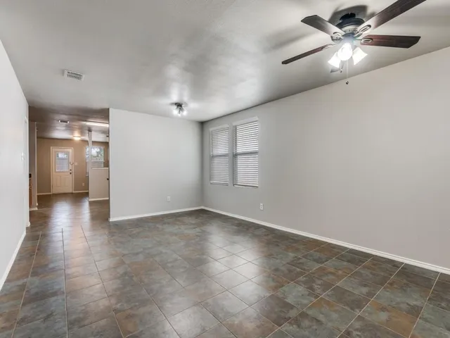 an empty room with closet and windows