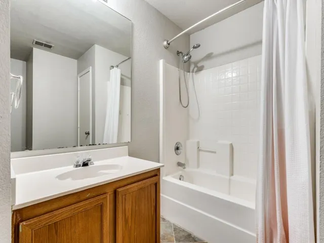 an empty room with windows and ceiling fan