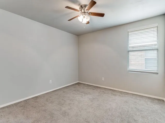an empty room with chandelier fan