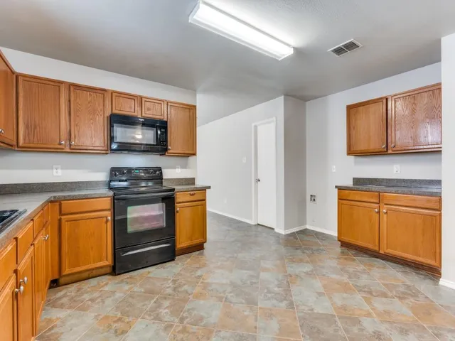 a large kitchen with stainless steel appliances and chandelier