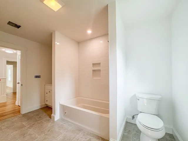 a bathroom with a granite countertop toilet a sink and bathtub
