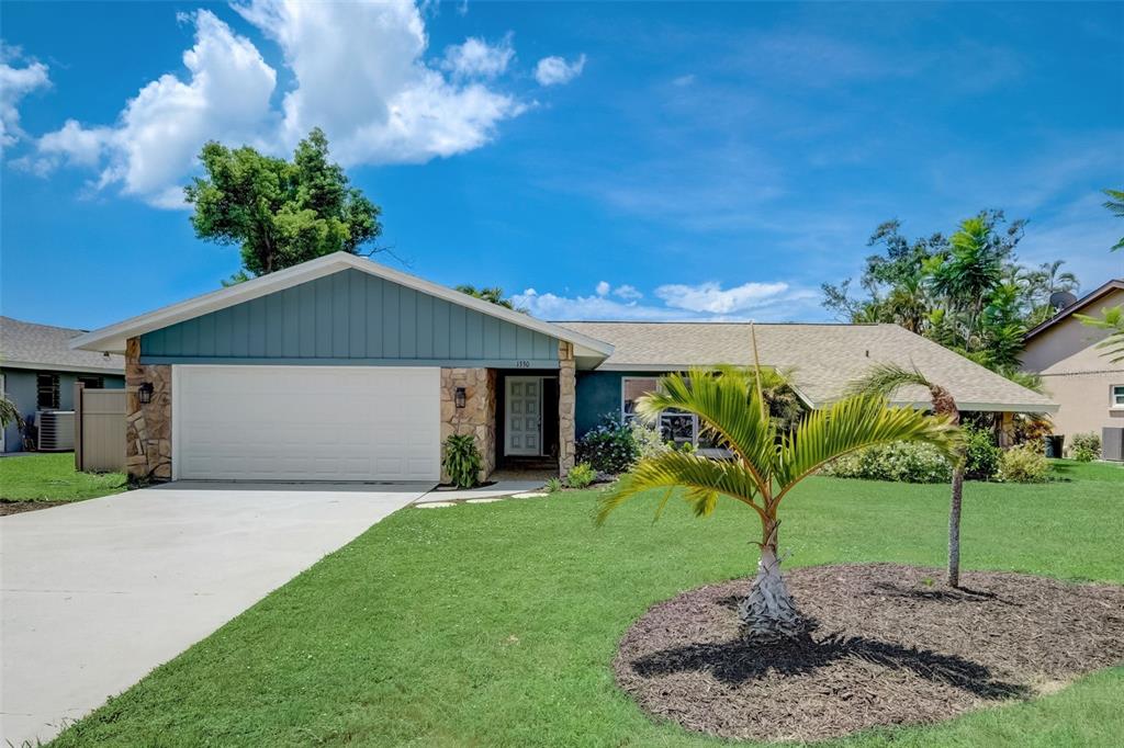1330 Pinebrook Way Venice, FL 34285 - Photo 1 of 1 a front view of a house with a yard and garage