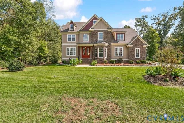 a front view of a house with a garden and trees