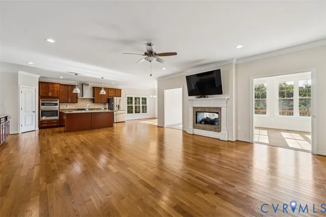 a view of a livingroom with a flat screen tv wooden floor and a kitchen