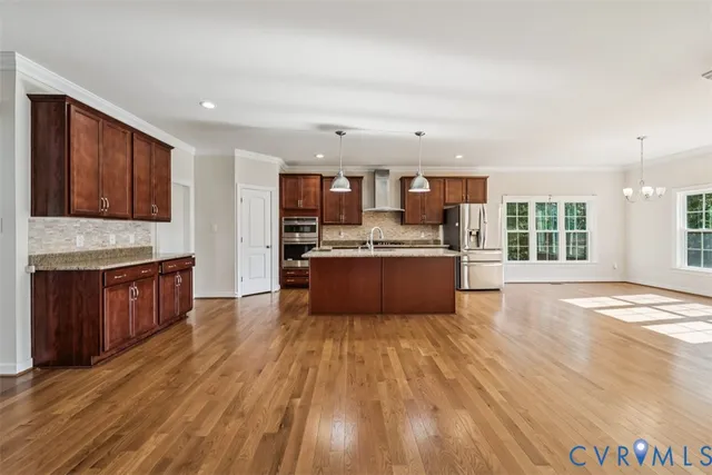 a large kitchen with wooden floors and stainless steel appliances