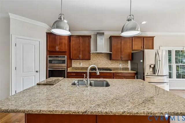 a kitchen with stainless steel appliances granite countertop a sink refrigerator and cabinets