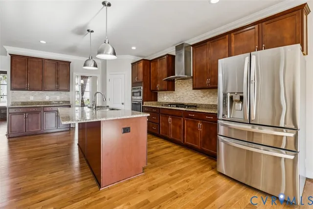 a kitchen with stainless steel appliances granite countertop a refrigerator a stove a sink and a microwave