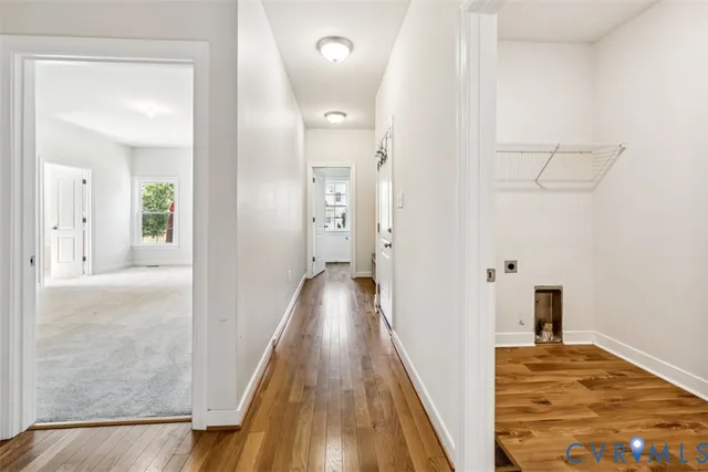 a view of a hallway with wooden floor and staircase