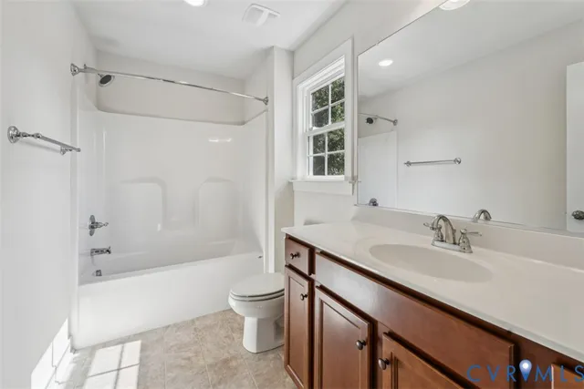 a bathroom with a granite countertop sink a toilet and shower
