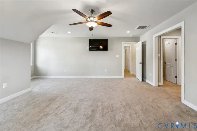 an empty room with windows and a ceiling fan