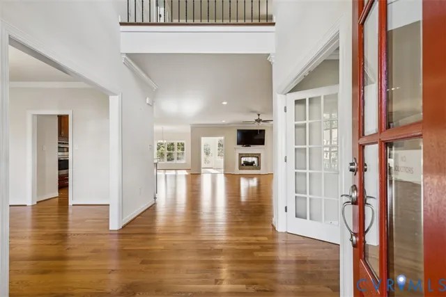 a view of empty room with wooden floor and a window