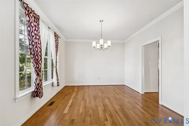 a view of a room with wooden floor and large windows