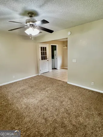 a view of an empty room with a chandelier fan
