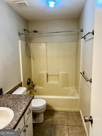 a bathroom with a granite countertop sink toilet a shower and a mirror