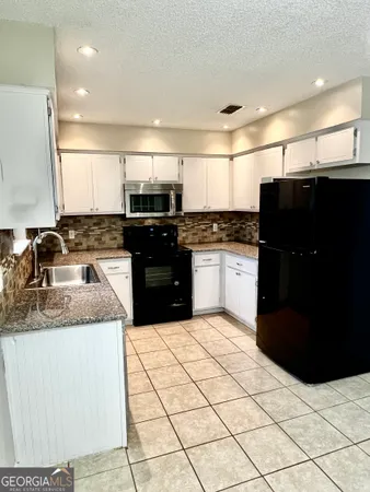 a kitchen with stainless steel appliances kitchen island granite countertop a sink and a stove