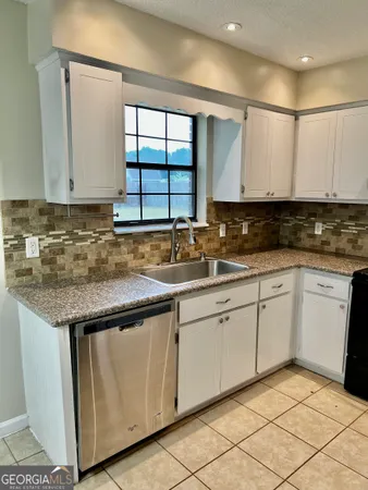 a kitchen with granite countertop a sink and a stove