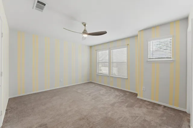 an empty room with a window and a fan