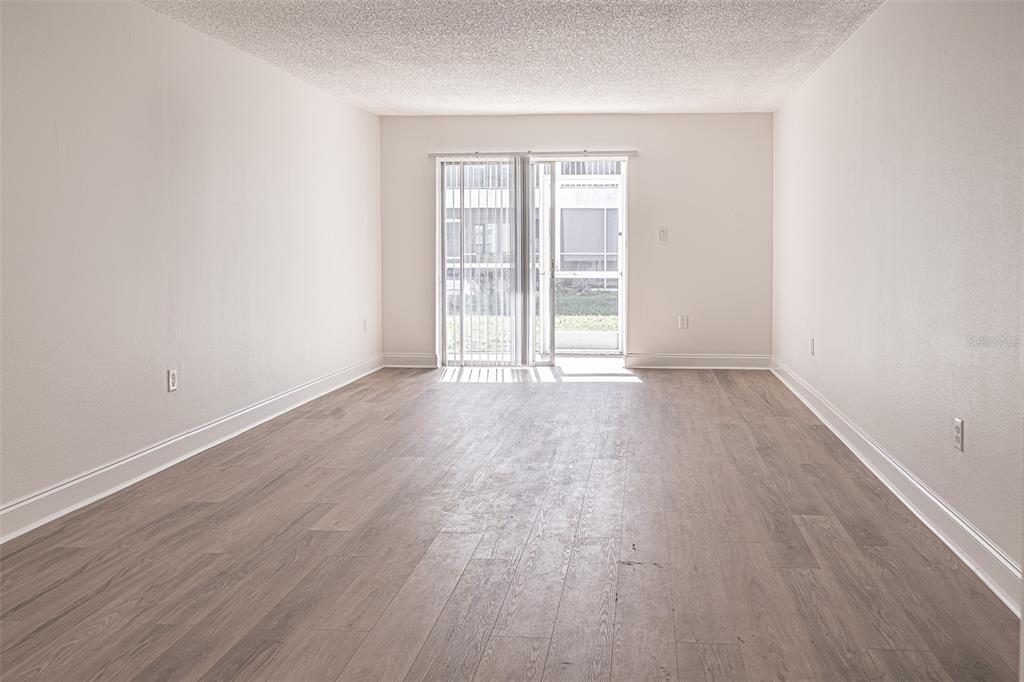 363 South McMullen Booth Road, Unit 107 Clearwater, FL 33759 - Photo 3 of 21 an empty room with wooden floor and windows