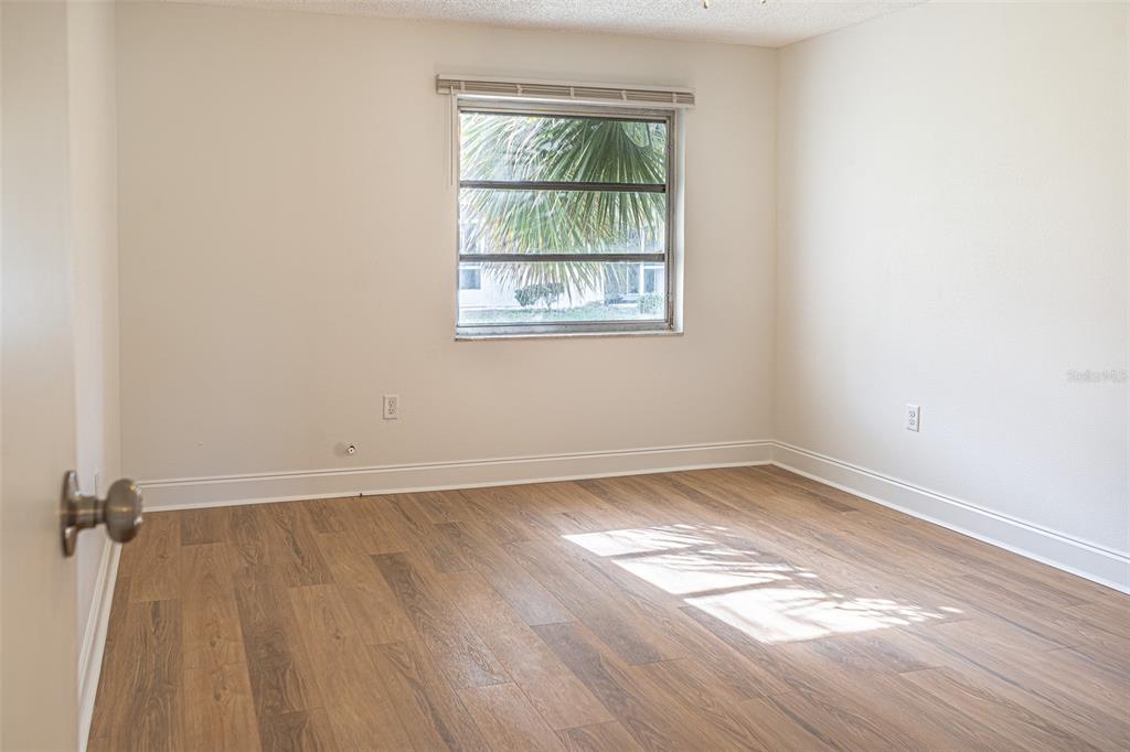 363 South McMullen Booth Road, Unit 107 Clearwater, FL 33759 - Photo 8 of 21 an empty room with wooden floor and windows