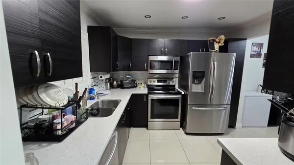 a kitchen with stainless steel appliances granite countertop a refrigerator stove and sink