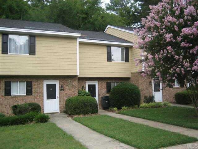 2102 Spring Forest Road, Unit 2102 Raleigh, NC 27615 - Photo 1 of 6 a front view of a house with a yard and trees