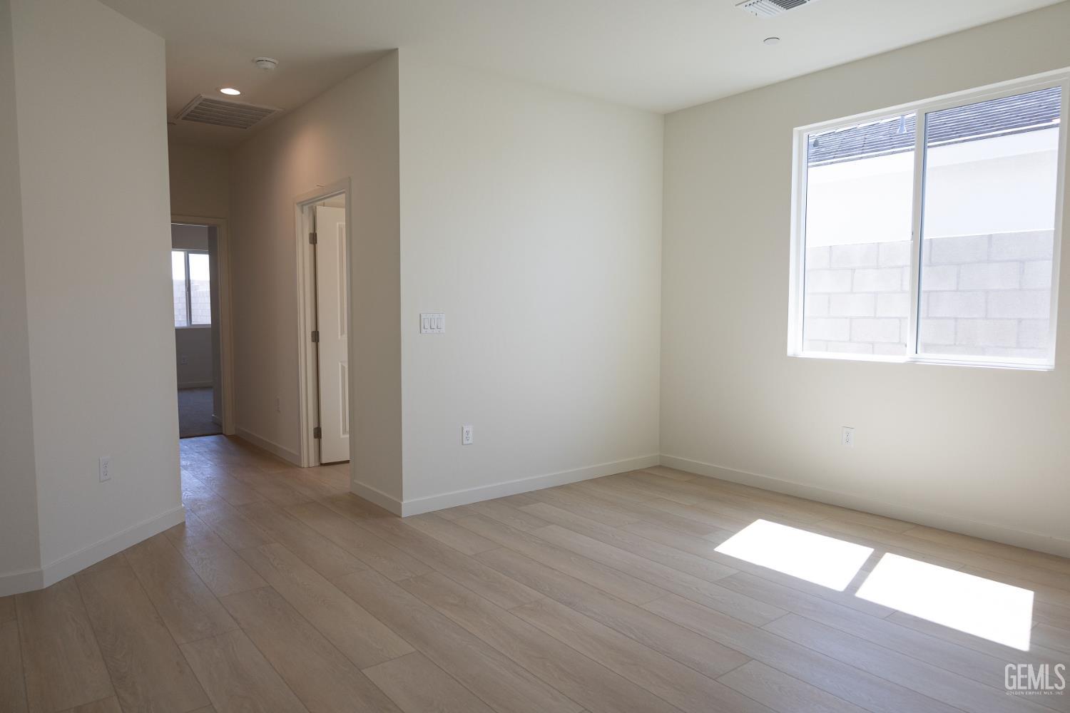 Undisclosed Address Bakersfield, CA 93311 - Photo 12 of 29 an empty room with wooden floor and windows