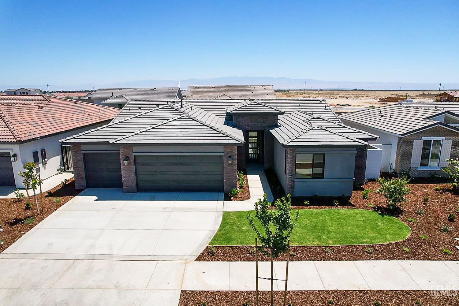 Undisclosed Address Bakersfield, CA 93311 - Photo 2 of 29 a front view of a house with a yard and garage