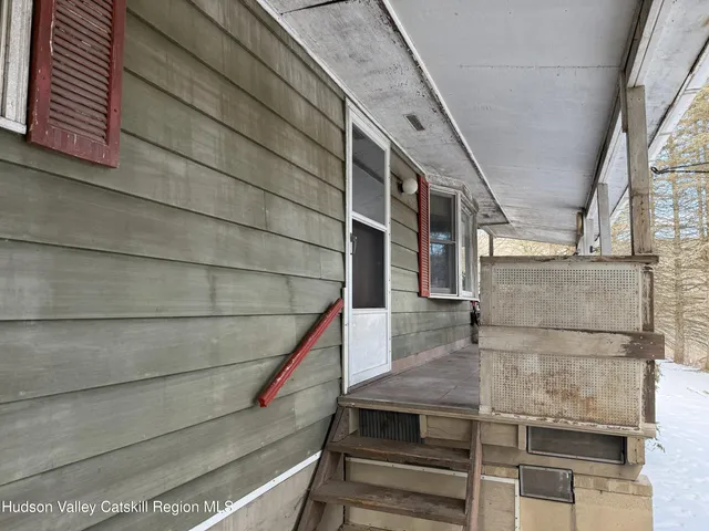 a view of a porch with furniture and floor to ceiling window
