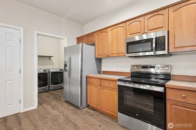 a kitchen with granite countertop a sink a counter space appliances and cabinets