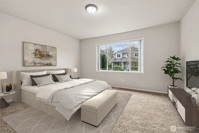 a bedroom with a bed a couch and a potted plant