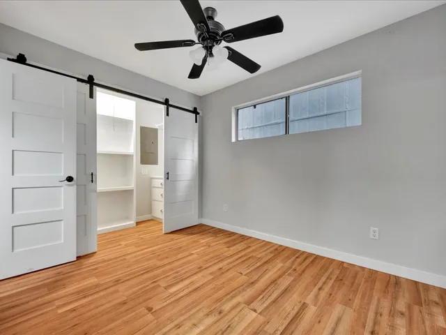 an empty room with wooden floor a ceiling fan and closet