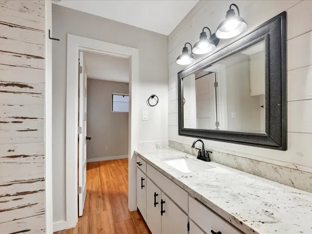 a bathroom with a granite countertop double vanity sink and a mirror