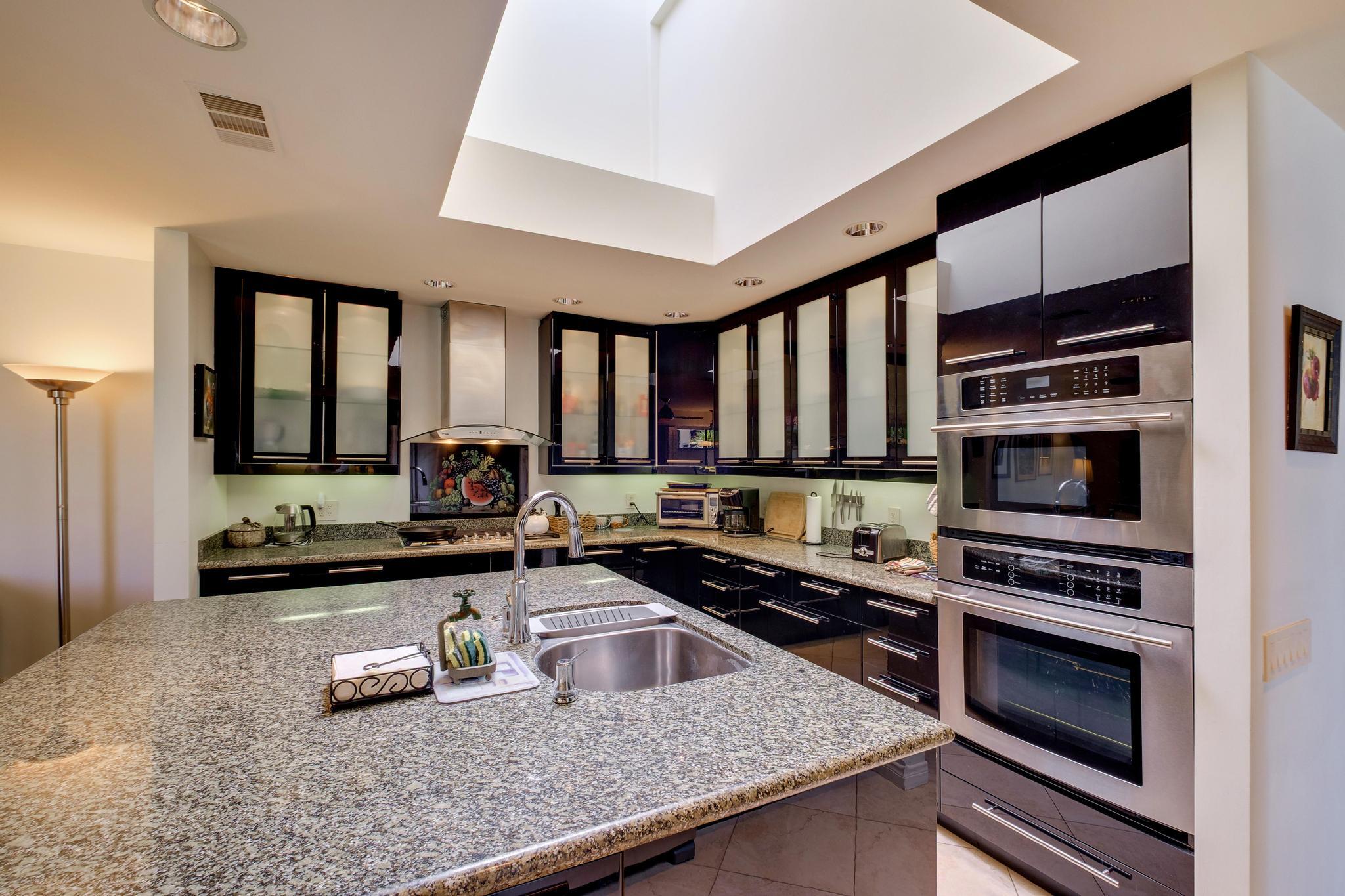 30 Columbia Drive Rancho Mirage, CA 92270 - Photo 22 of 49 a kitchen with stainless steel appliances a stove a sink and a microwave