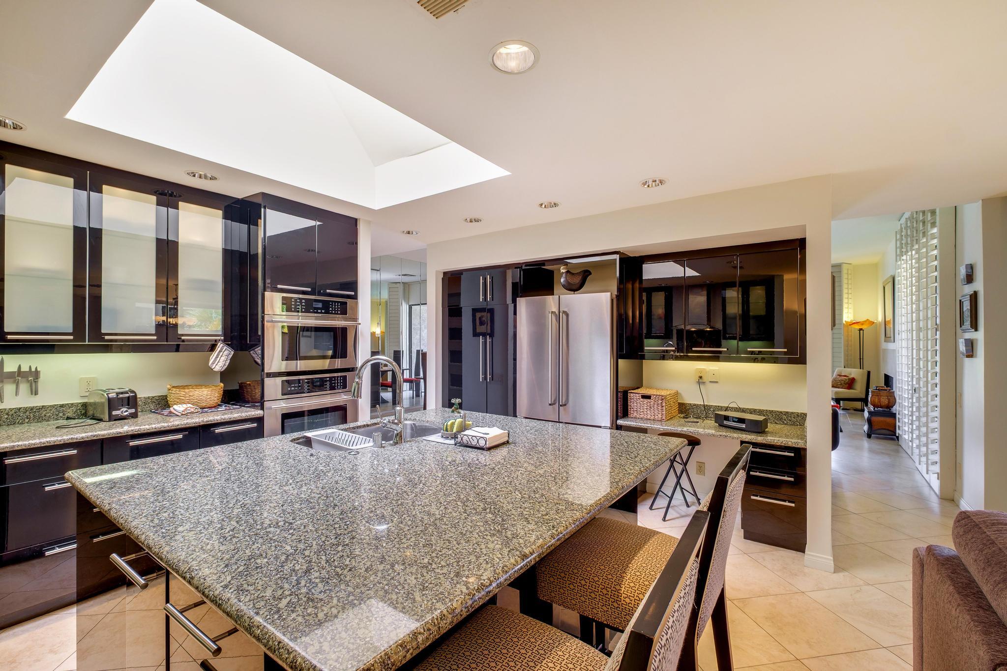 30 Columbia Drive Rancho Mirage, CA 92270 - Photo 23 of 49 a kitchen with stainless steel appliances granite countertop a stove and a dining table