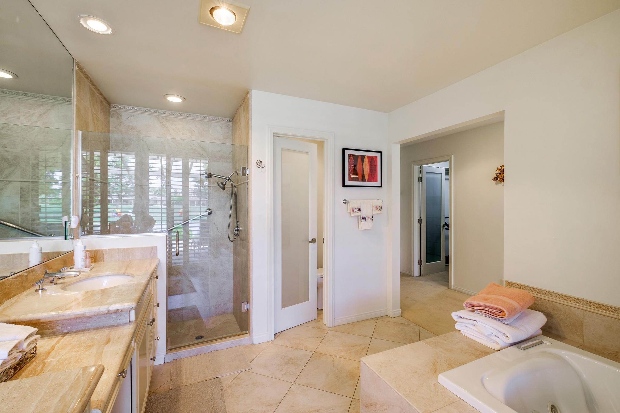 30 Columbia Drive Rancho Mirage, CA 92270 - Photo 30 of 49 a spacious bedroom with a bed and a chandelier