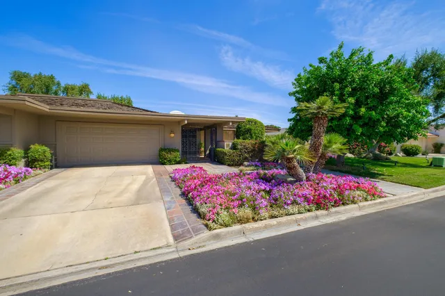 a view of a patio with table and chairs potted plants and floor to ceiling window