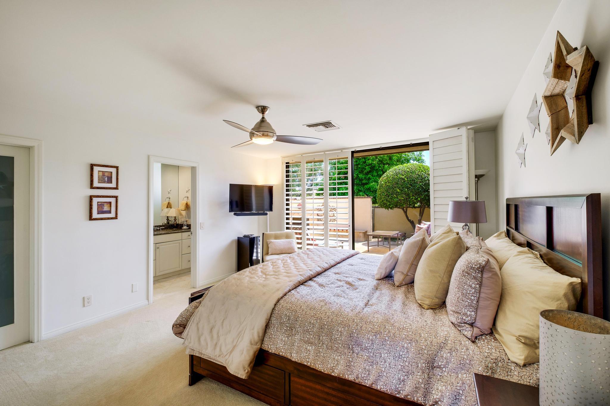 30 Columbia Drive Rancho Mirage, CA 92270 - Photo 37 of 49 a bedroom with a bed flat screen tv and a large window