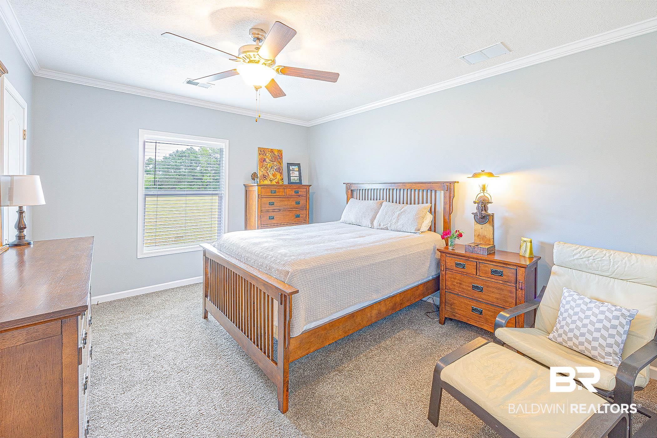 16000 John Bauer Road Summerdale, AL 36580 - Photo 24 of 34 Bedroom with a textured ceiling, ornamental molding, visible vents, and light colored carpet