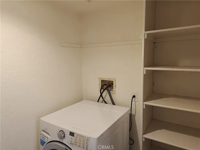 an empty room with wooden floor fireplace and windows