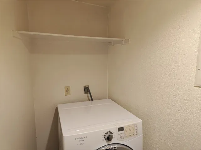 a kitchen with stainless steel appliances granite countertop a refrigerator a sink dishwasher a stove and a dining table with wooden floor